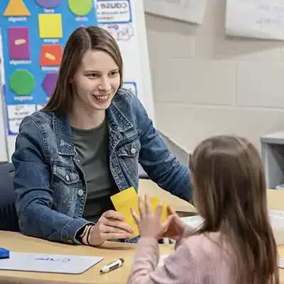 Female teacher using flashcards to educate a young child.