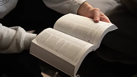 Man holding an open Bible.